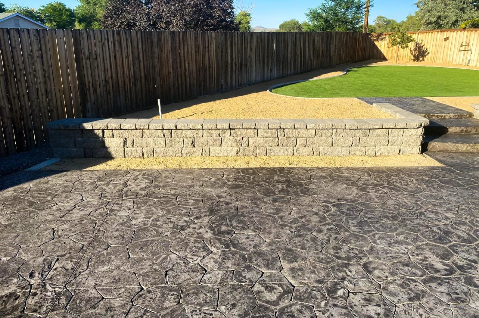 Block retaining wall with stamped concrete patio